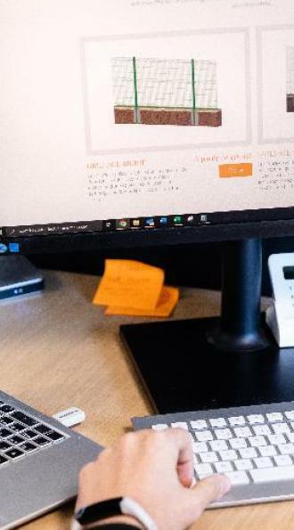 Main sur un clavier devant un ordinateur