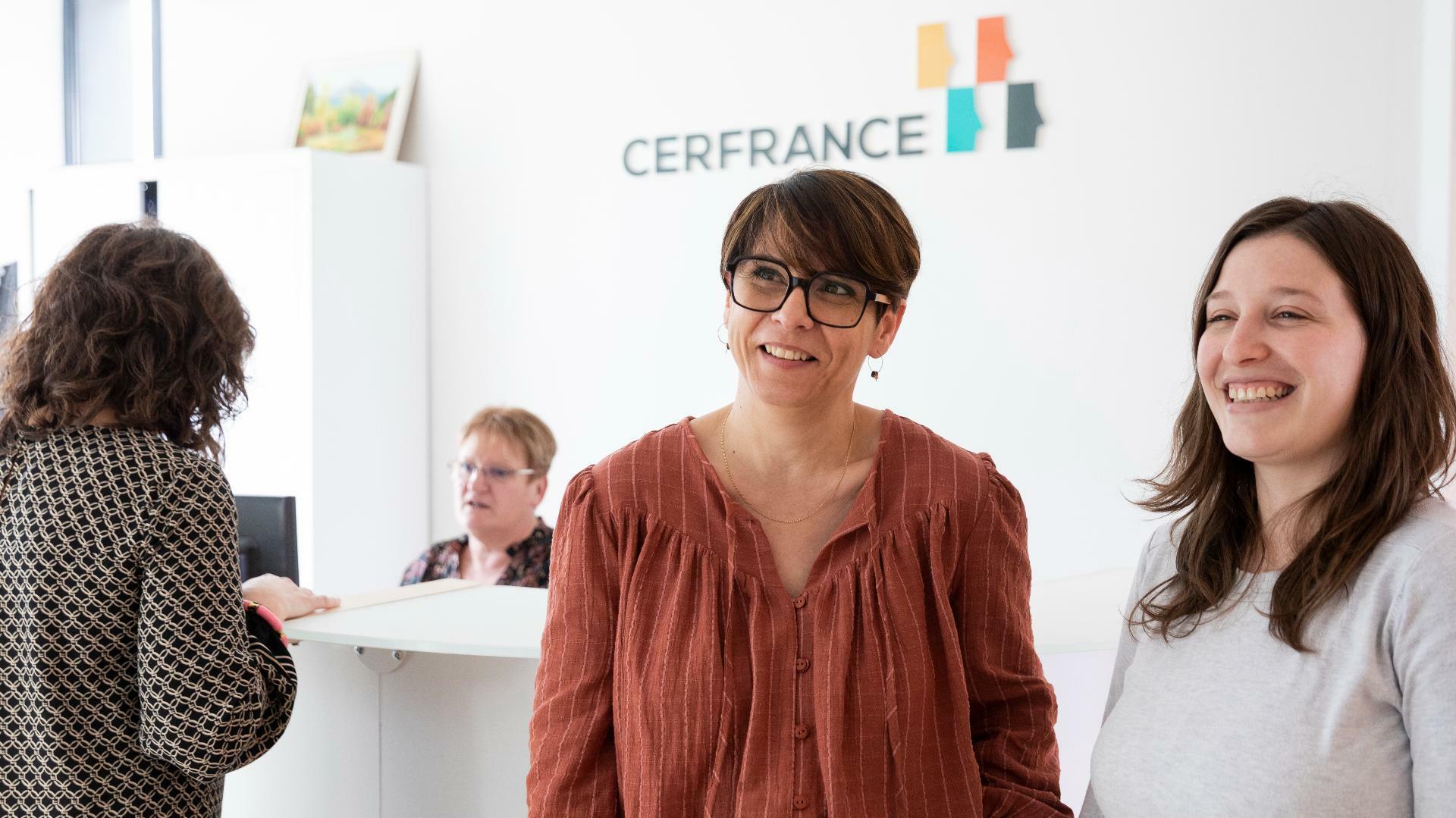 Deux femmes discutent devant une banque d'accueil Cerfrance