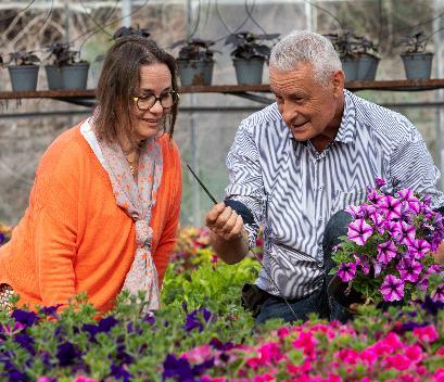 Un homme et une femme dans une serre devant des fleurs